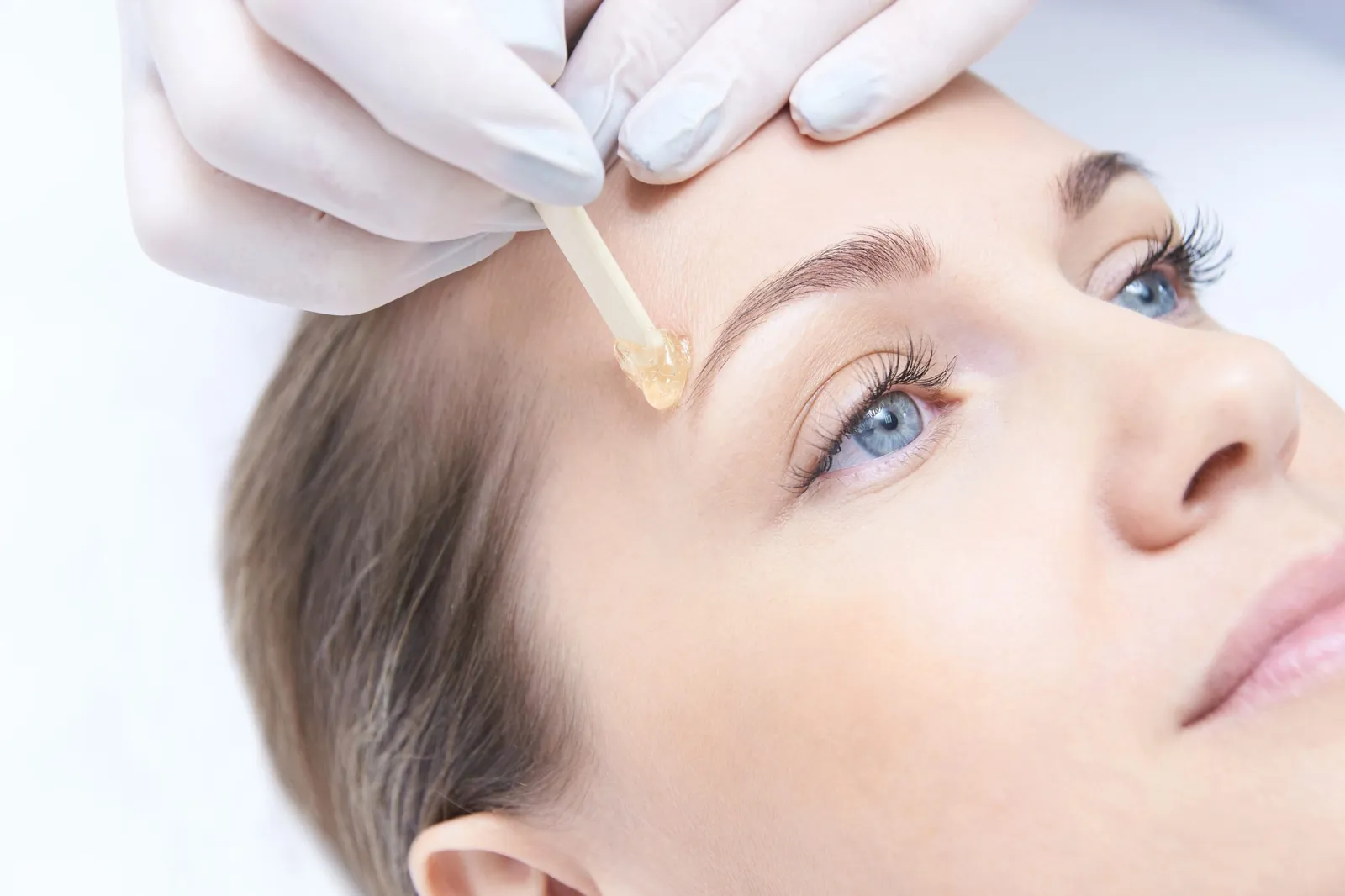 Applying warm wax along the brow line