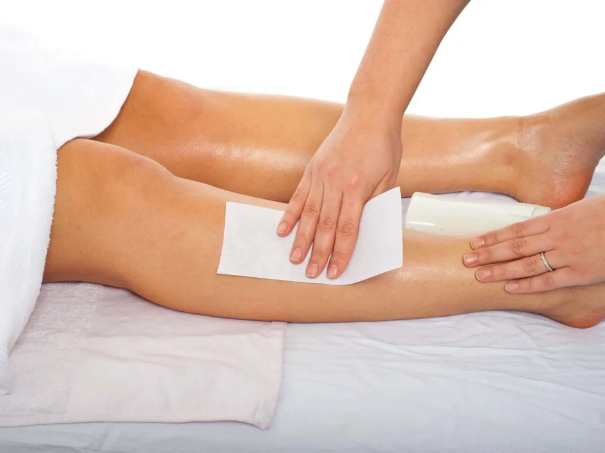 Smoothing a wax strip on the leg
